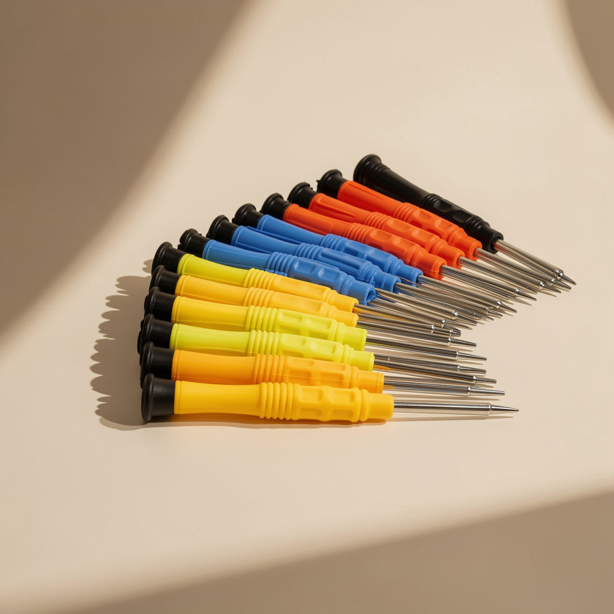 Bitdriver Mobile Phone Repair Screwdriver set fanned out in rows of yellow, orange, blue and black handles
