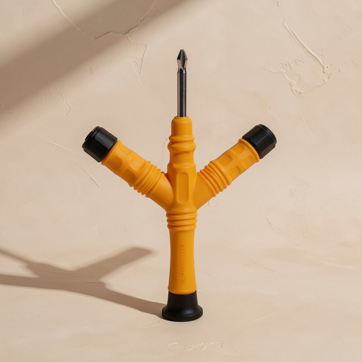 Bitdriver – Yellow-orange screwdriver with ribbed handle and Phillips bit, standing upright beside two angled black-capped