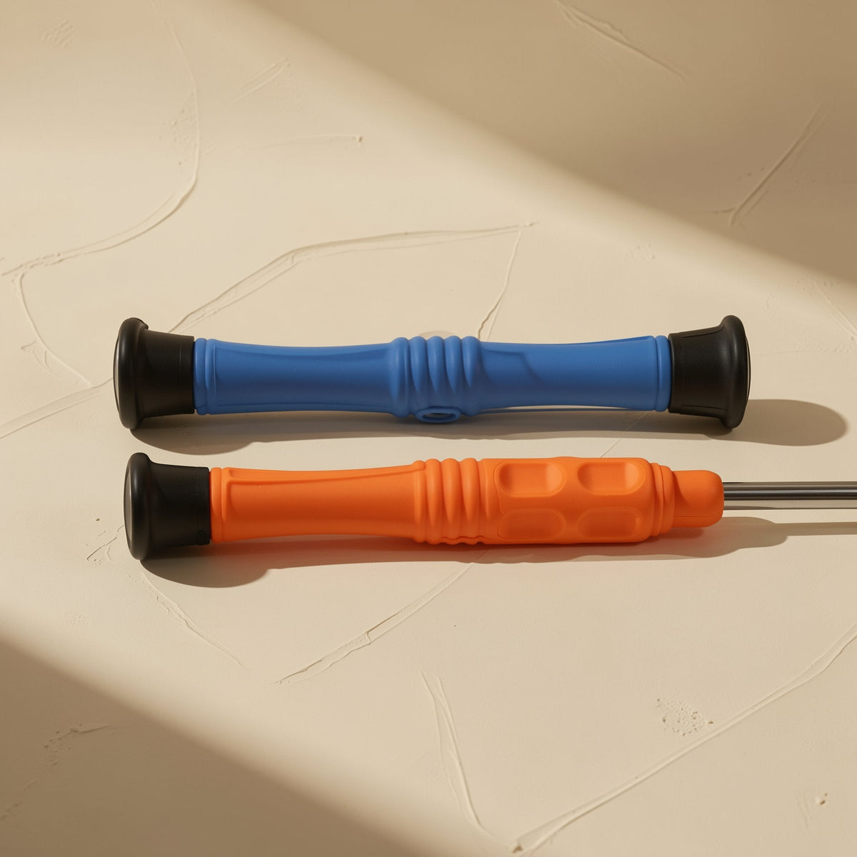 Bitdriver – Blue and orange screwdrivers lying side by side, showing grip ribbing and black end caps