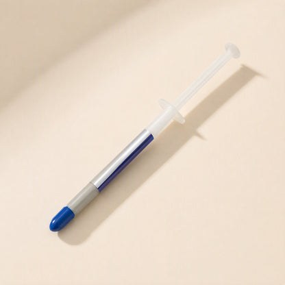 Thermspread – Single syringe of thermal paste lying diagonally, silver label wrapped around the blue barrel