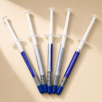 Thermspread – Five thermal paste syringes fanned out in a row, showing printed labels and graduated markings