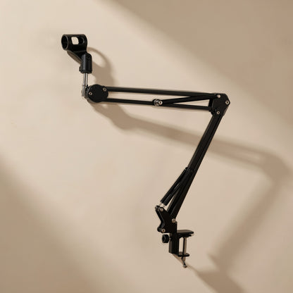 Clipgrip – Black boom arm with mic clip and clamp, mounted against a beige wall in soft side light