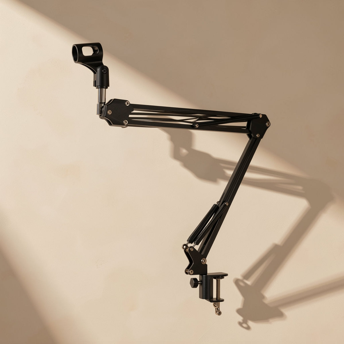Clipgrip – Same black swing arm angled slightly differently, with long diagonal shadows across the cream wall