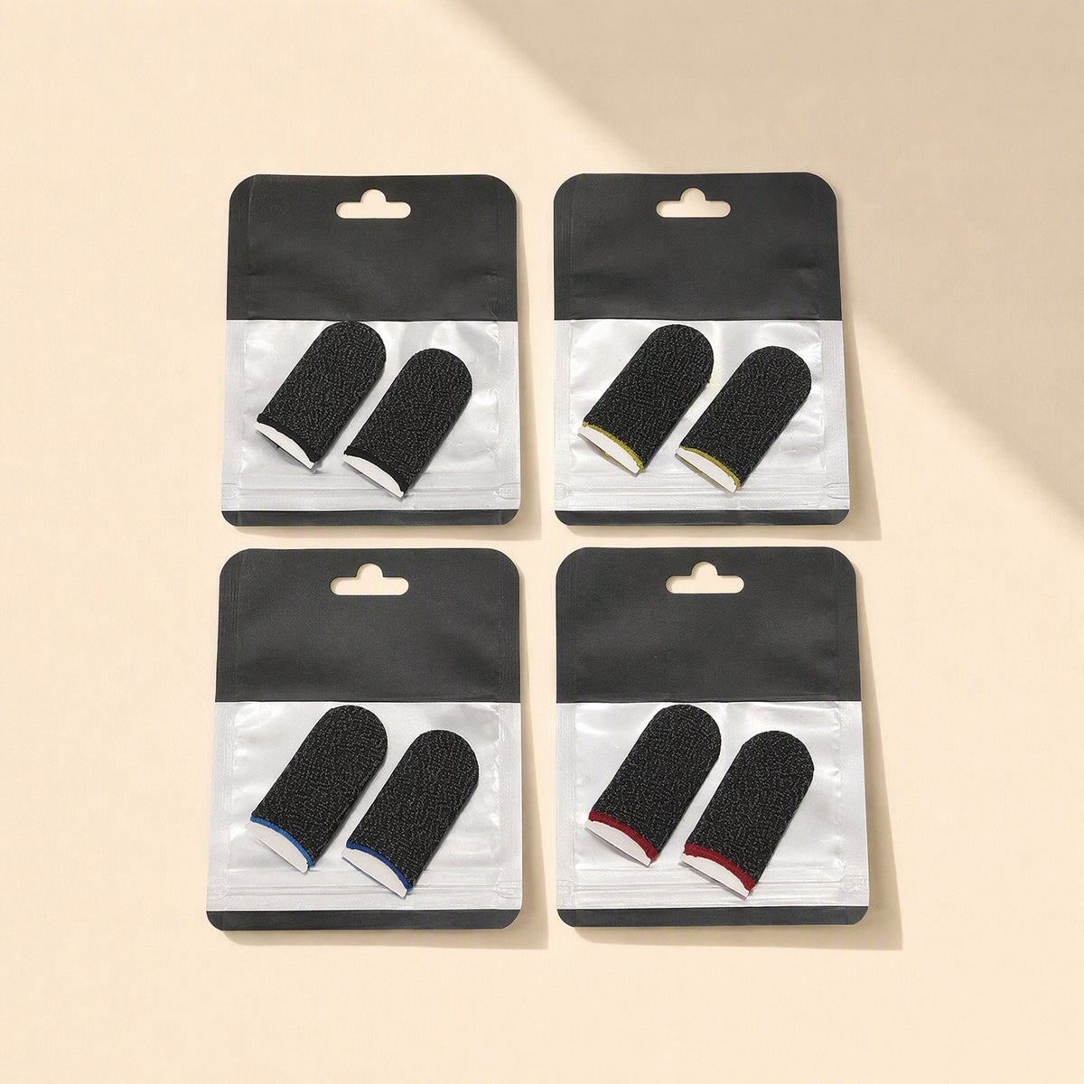 Gamegrip Touchscreen Finger Sleeve – four bagged pairs of black speckled thumb sleeves with white, yellow, blue and red cuffs