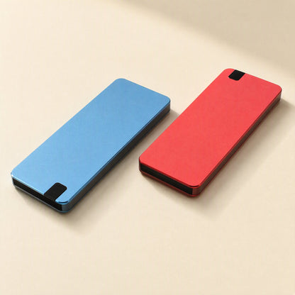 Solidvault Portable SSD – blue and red slim metal drives lying side by side on a cream surface, each with a black end tip