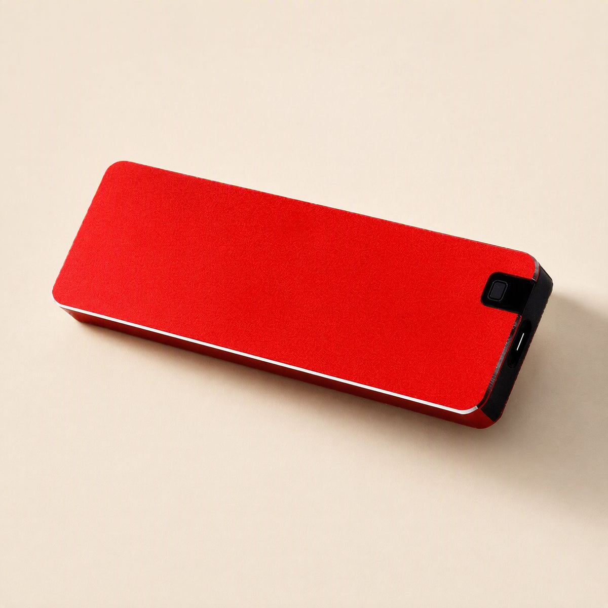 Solidvault Portable SSD – red metal drive lying flat, with the USB-C port and small button on its black end