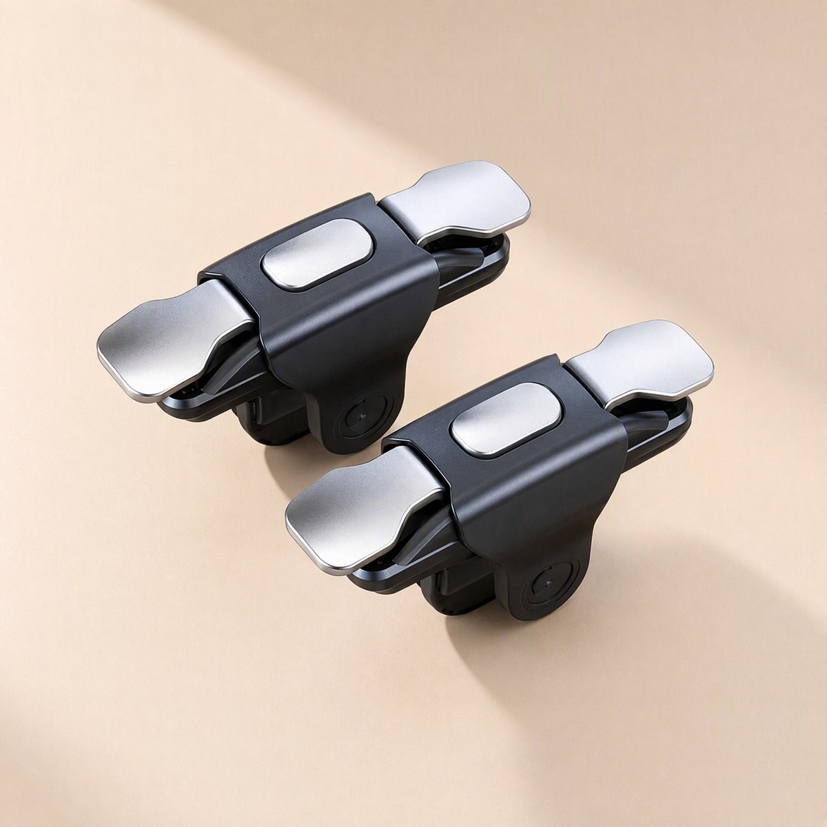 Gameglide Wireless Game Controller – two black triggers with silver metal buttons and a flat oval pad, top-down view on beige