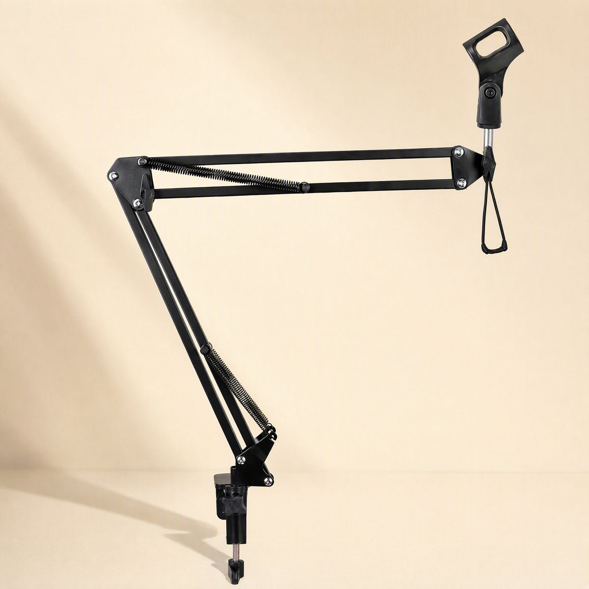 Standfold – Black microphone boom arm stretched out sideways, showing springs and clip holder on a warm beige background