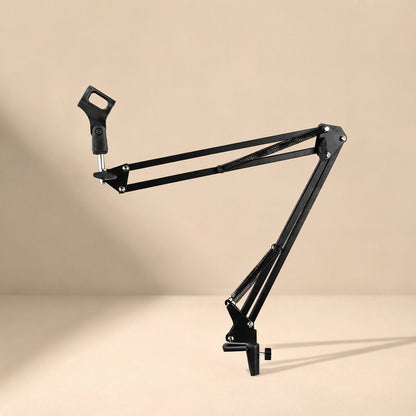 Standfold – Mic stand with the boom arm raised at an angle and the C-clamp base resting on a tan surface