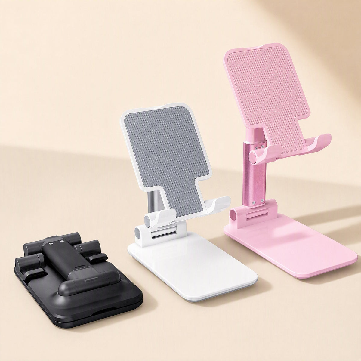 Fliprest Foldable Desktop Phone Holder in black, white and pink, shown folded flat and standing upright