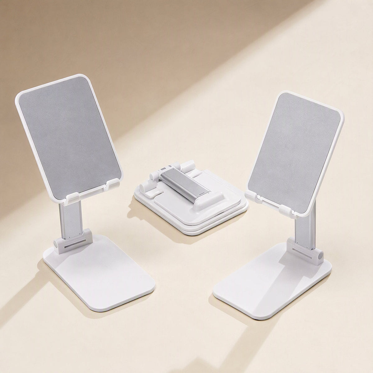 Fliprest – Two white holders standing with grey pads, and a third folded flat between them, on a beige backdrop