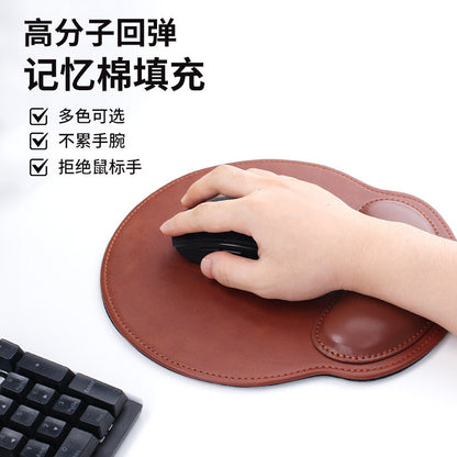Wristcradle – Hand resting on a brown leather round mouse pad with stitched edge, a black mouse and keyboard nearby