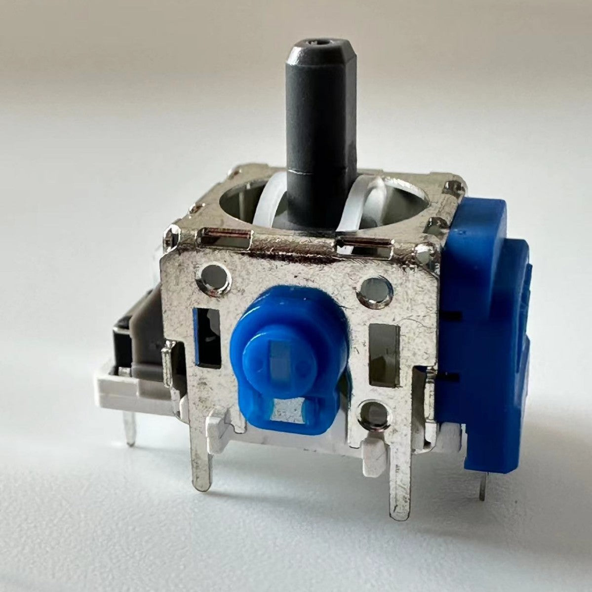 Haldrift – Close-up of a single joystick module showing the silver metal frame and blue round cap