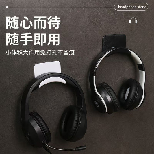 Adhehold – Two wall hooks, one white and one black, each holding over-ear headphones on a dark wall, one with a boom mic