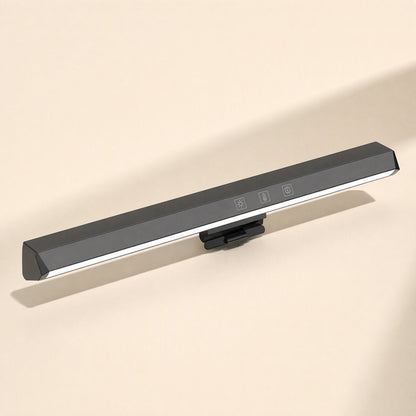 Screenglow – Black monitor lamp bar with glowing white light strip and touch buttons, angled front view on a beige backdrop