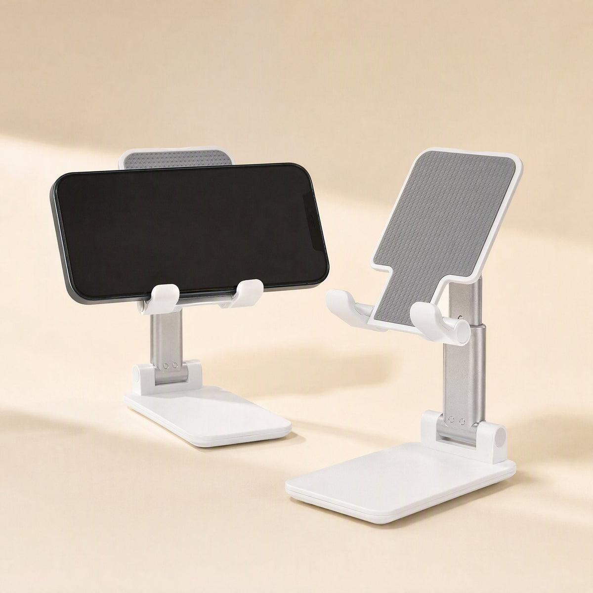 Foldgrip – Two white phone stands on a beige surface, one holding a black phone in landscape orientation