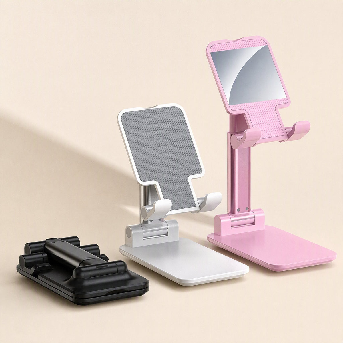 Phonehinge – Three folding phone stands in black, white and pink, with the black one folded flat and the pink one extended