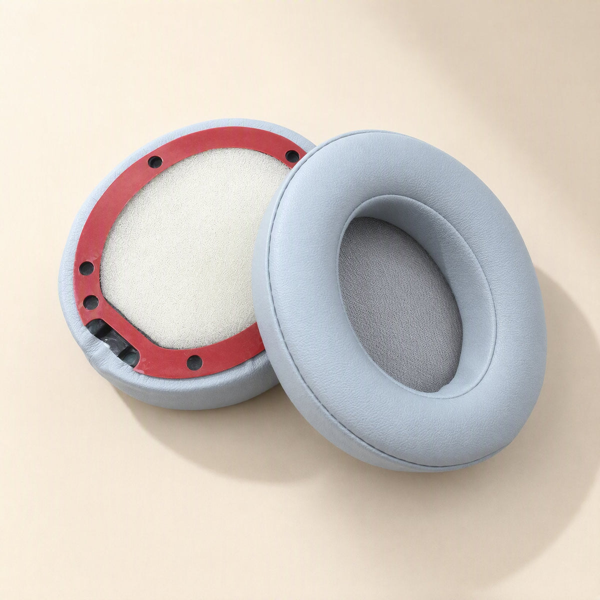 Leatherhug Headphone Covers – light gray-blue ear cushion next to an upturned one with a red ring and pale mesh lining