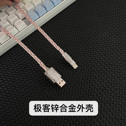 Braidlink – Pink braided cable with metal USB-A and USB-C connectors held above a white and blue keyboard