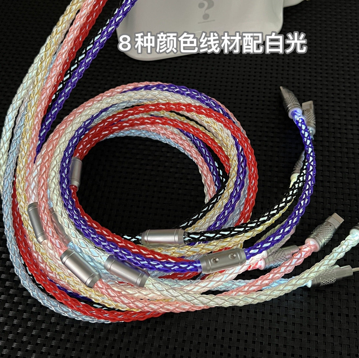 Braidlink – Eight coiled braided cables in different colours with metal connectors, arranged together