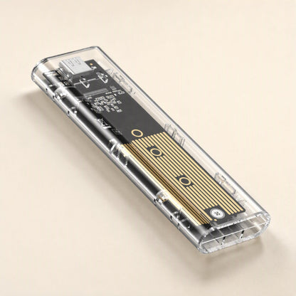 Driveclear – Angled close-up of the clear enclosure showing the gold heatsink strip, screw and USB-C port at the end