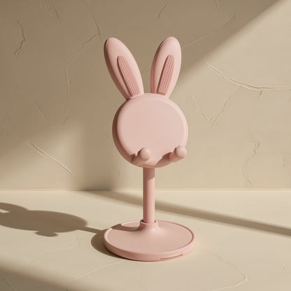 Bunnyrest – Pink rabbit stand seen from the back with textured ears, slim pole and round base in angled sunlight