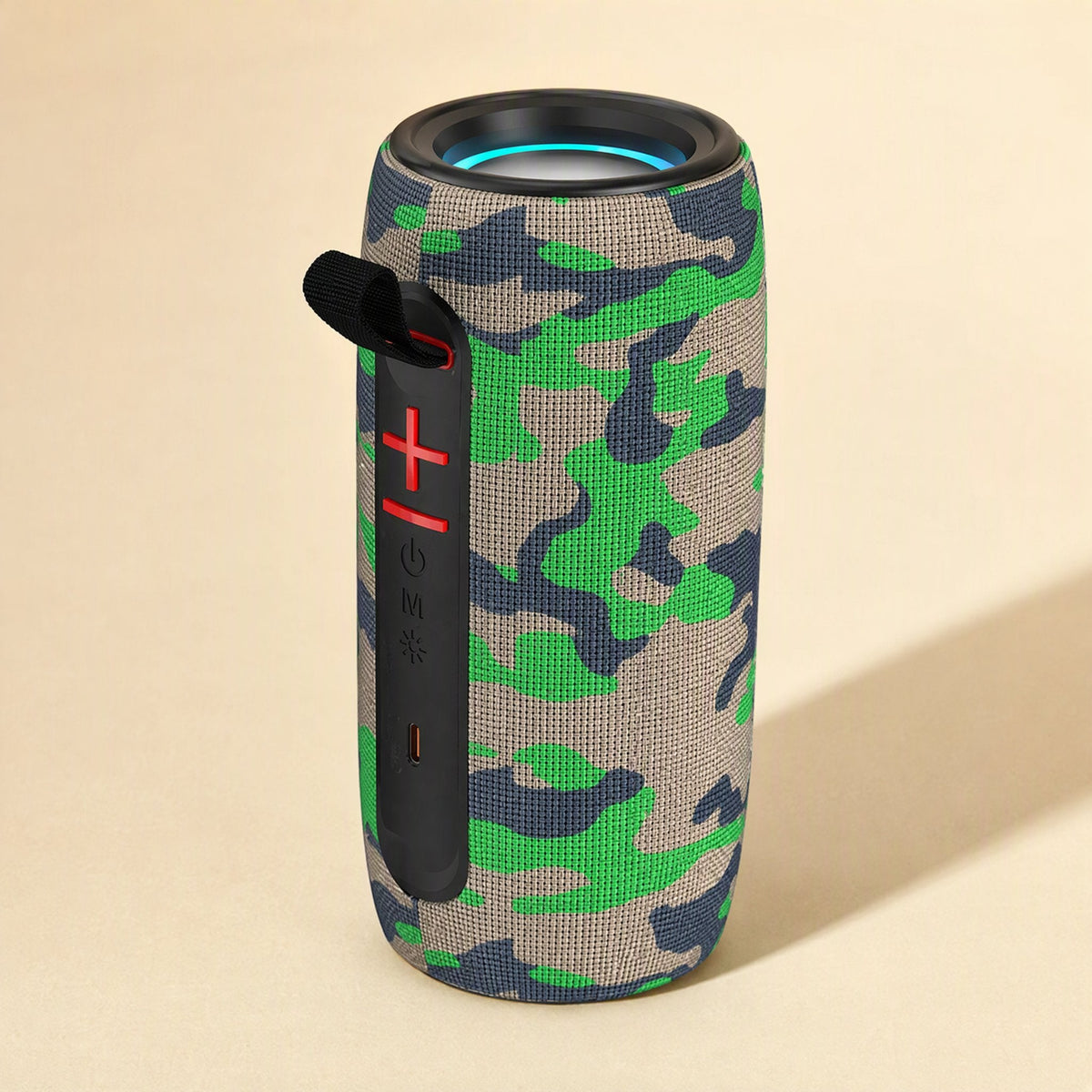 Twinbeat – Camouflage fabric speaker standing upright, showing red plus and minus buttons, carry strap and USB-C port