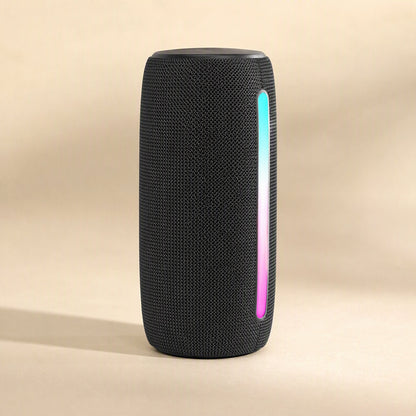Twinbeat – Black fabric speaker seen from the front with a cyan and pink glowing light strip down one side
