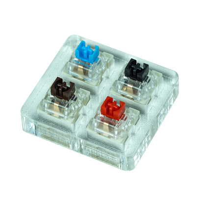 Clixon – Four switches in blue, black, brown and red mounted in a clear acrylic tester block, seen from above