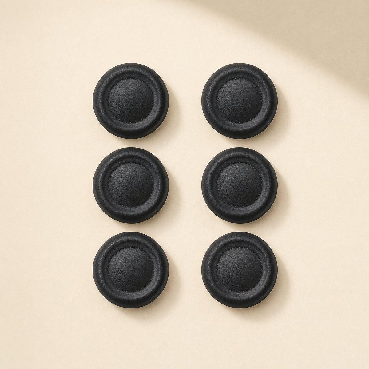 Thumbtread ABS PS5 Controller Joystick Cap, six black caps in three rows on a cream background, top view