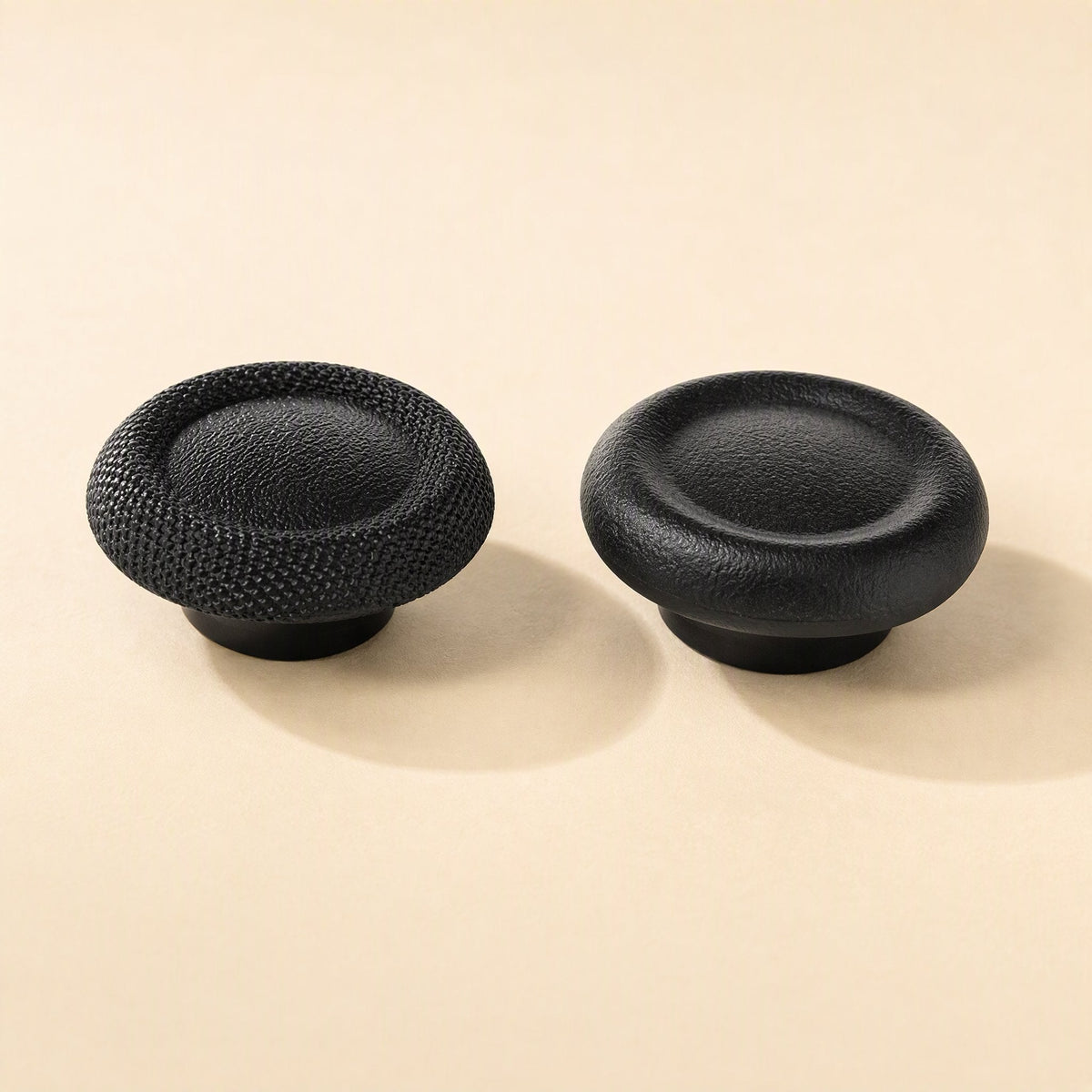 Thumbtread – Two black joystick caps side by side, one with a dotted grip texture and one with a smooth leather-like surface