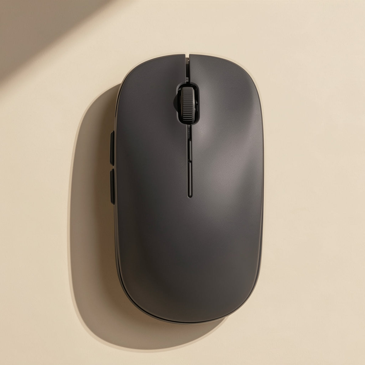 Slimclick Ultra-Thin Bluetooth Wireless Mouse in charcoal gray, top view with side buttons on a cream surface
