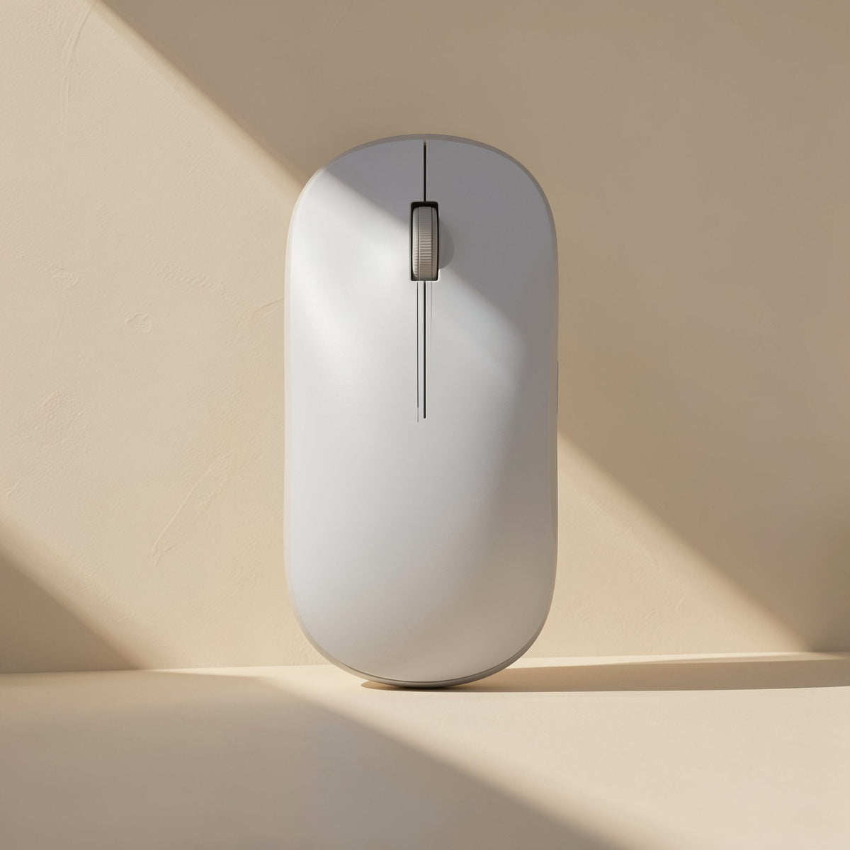 Slimclick – White slim wireless mouse standing upright against a cream wall with a diagonal band of sunlight