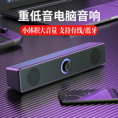 Duokast – Black soundbar speaker on a desk beside a laptop and smartphone, with Chinese text promoting bass and Bluetooth