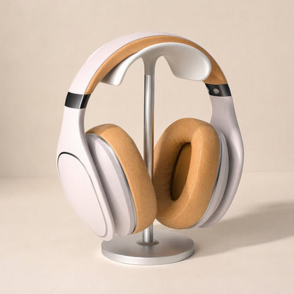 Hookrest – Silver stand holding cream over-ear headphones with tan leather ear cushions on a beige background