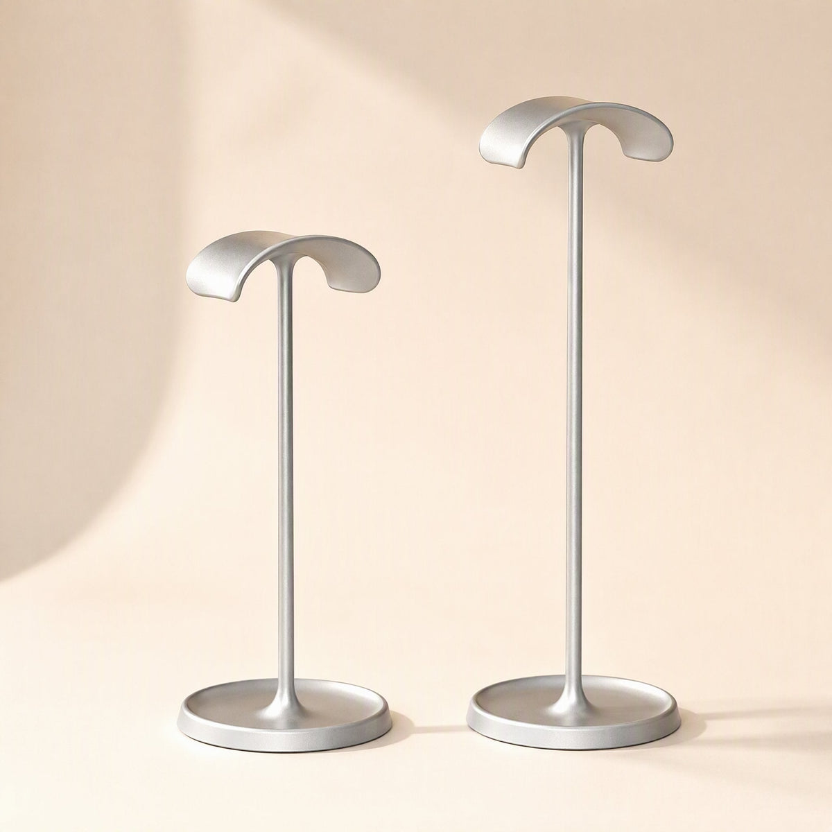 Hookrest – Two silver headphone stands side by side, a shorter one on the left and a taller one on the right