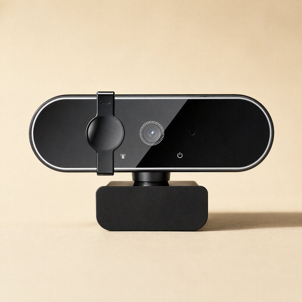 Soundglance – Straight-on view of webcam on beige background showing lens ring, power icon, and privacy cover at left