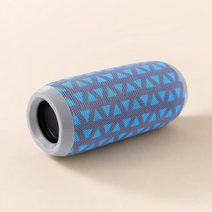 Pocketbeat – Blue and grey triangle-patterned speaker lying on its side, showing the grey end ring and speaker opening