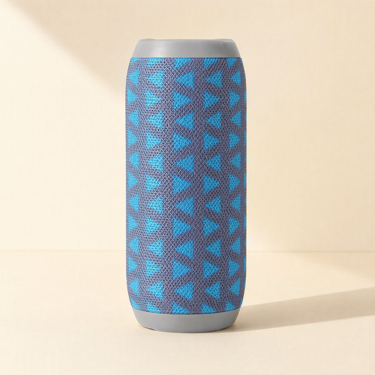 Pocketbeat – Front view of the blue triangle-patterned speaker standing upright on a cream background