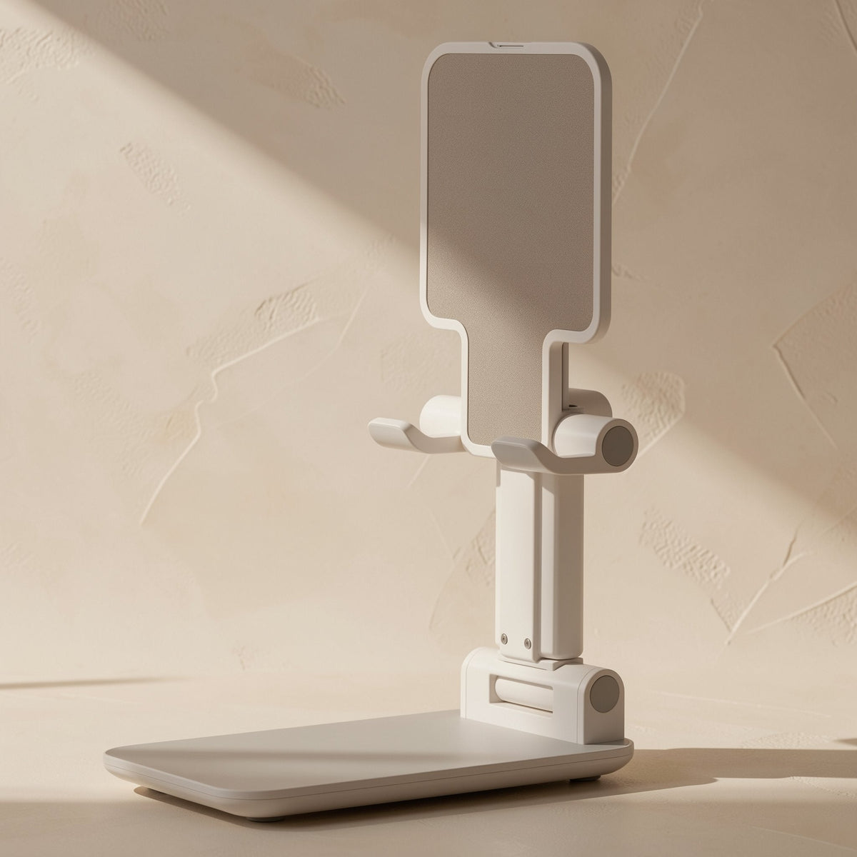 Foldprop – Front view of the white foldable phone stand with an empty cradle, extended arm and flat base