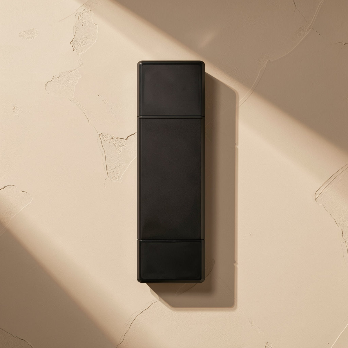 Readlink – Top-down view of the black reader's plastic body, with a hard diagonal shadow across the beige surface
