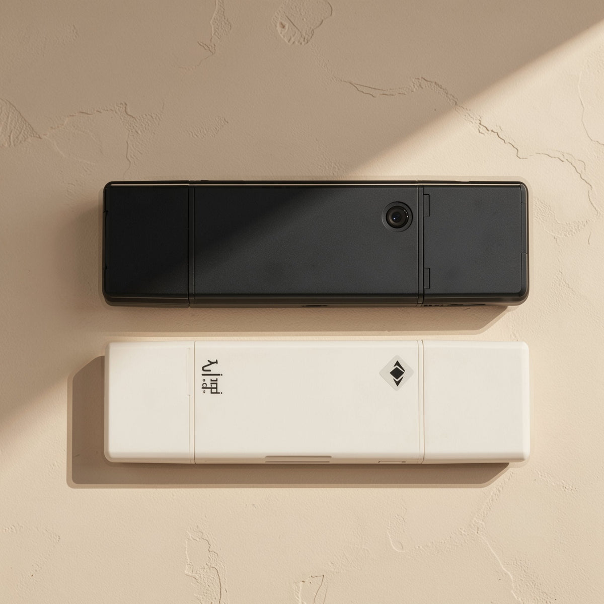 Readlink – Black and white readers stacked, showing the card slot, a small round button and an engraved diamond mark