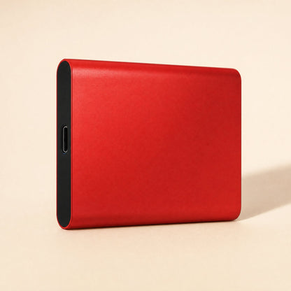 Datapocket – Red metal portable SSD at an angle showing its black end panel and USB-C port on a peach backdrop