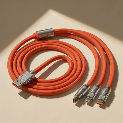 Plugtrio – Coiled orange three-head cable with USB-A plug and three metal connector tips on a sunlit surface