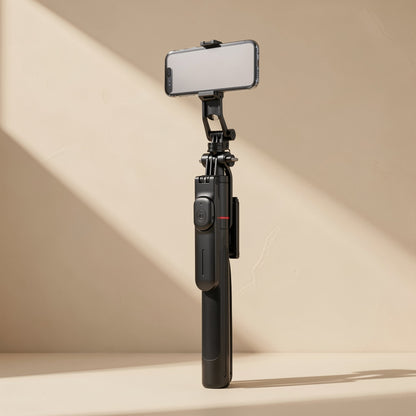 Snapframe Stainless Steel Bluetooth Selfie Stick holding a phone upright against a beige wall in angled light
