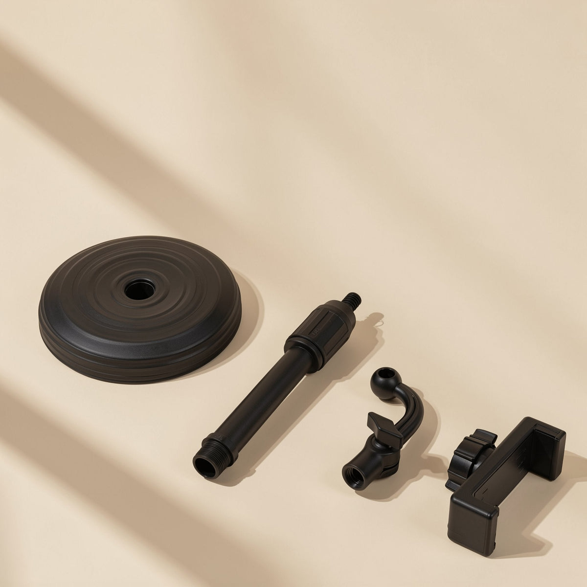 Tiltperch – Disassembled black phone bracket parts: round base, telescopic pole, curved neck joint and phone clamp