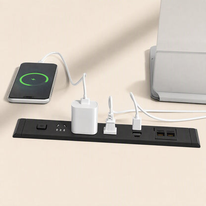 Desknest – Black socket on a desk charging a phone, with a power adapter, a plug in use and two network ports beside it