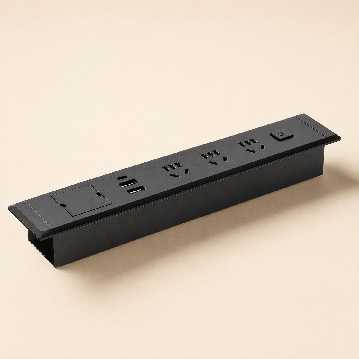 Desknest – Black embedded socket at an angle, showing its recessed housing, three outlets, USB ports and switch