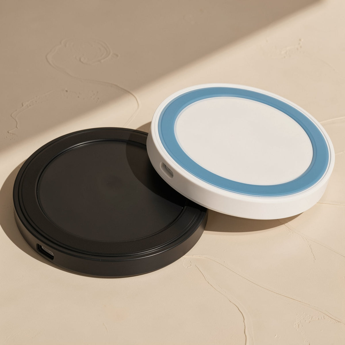 Voltrest – Black and white-with-blue-ring round chargers side by side, each with a USB port on the edge