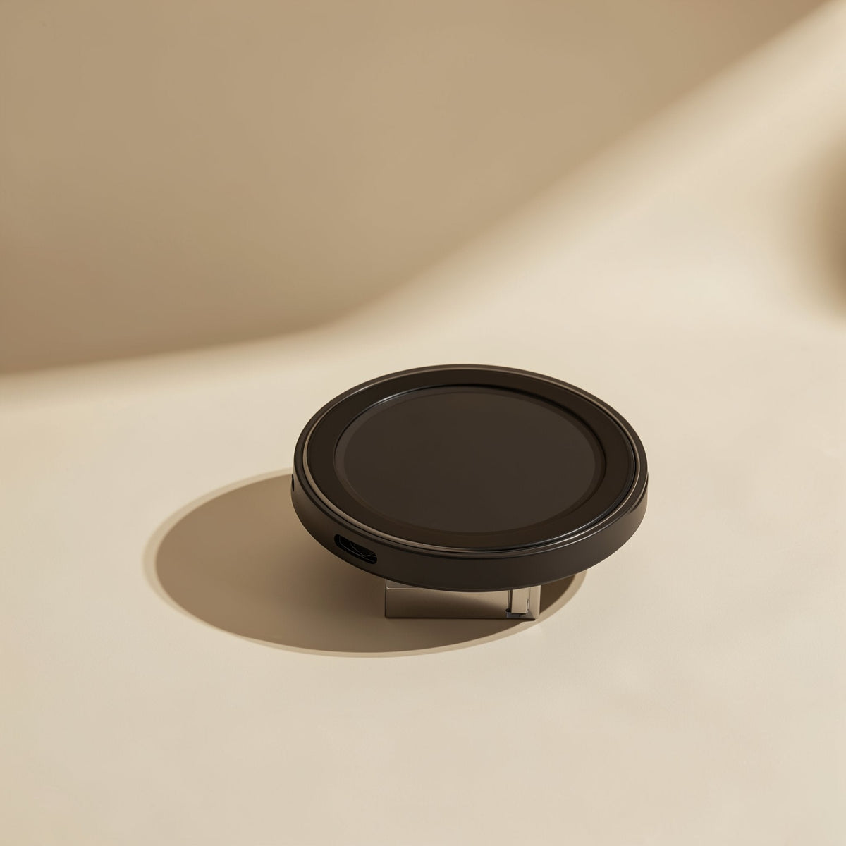 Voltrest – Slim black round wireless charger with a ridged rim and a port on its side, casting a soft shadow